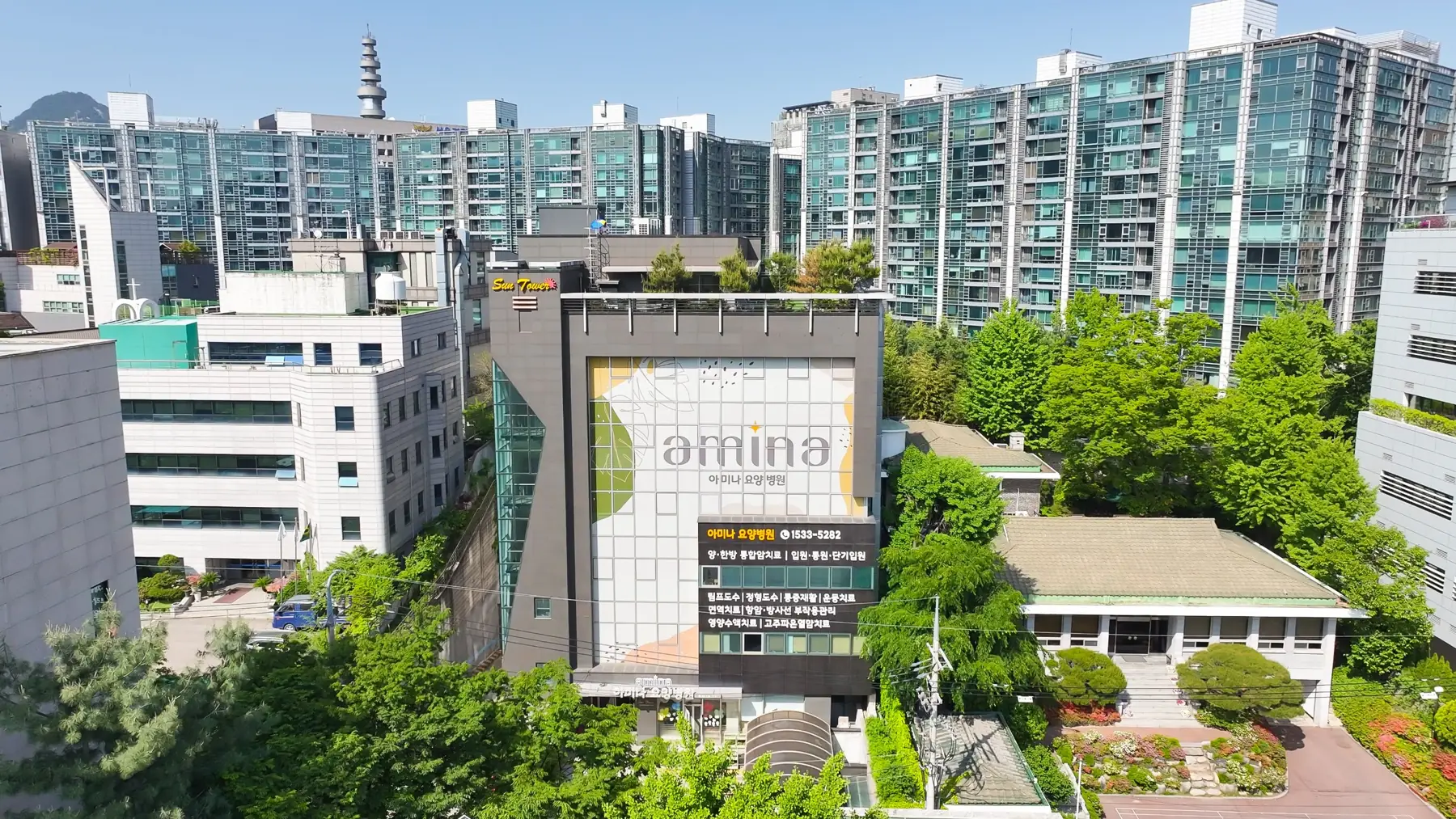 인왕산과 도심을 배경으로 녹지에 둘러싸인 아미나요양병원 항공 사진